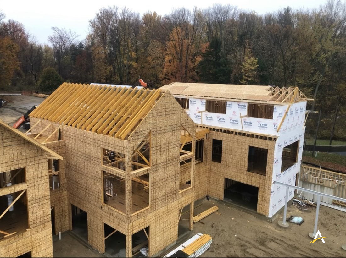 Aerial view of roof framing and house wrap in progress