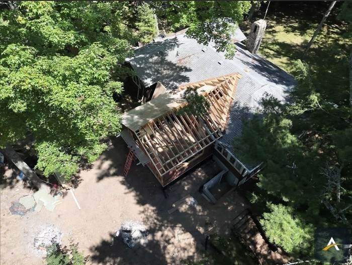 Aerial view of roof trusses framed against the tree line