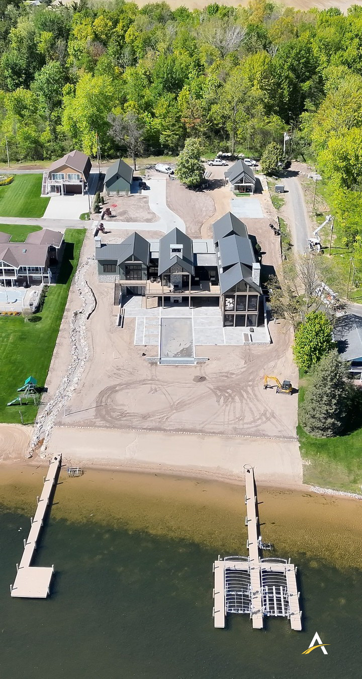 Aerial view of the completed lakefront home with private dock and waterfront