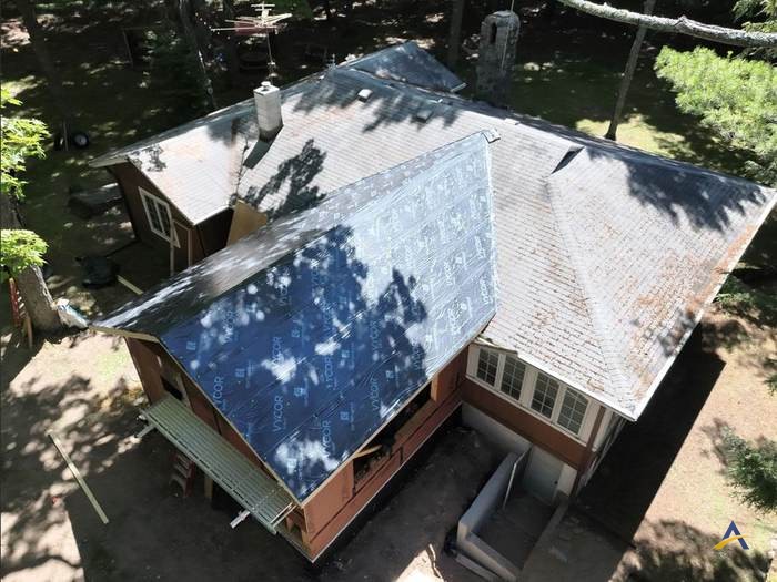 Angled view of underlayment installation alongside the original roof