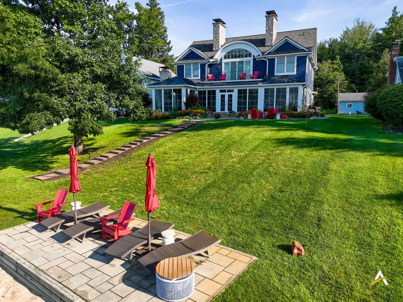 Wide daylight view of the rear lawn and home