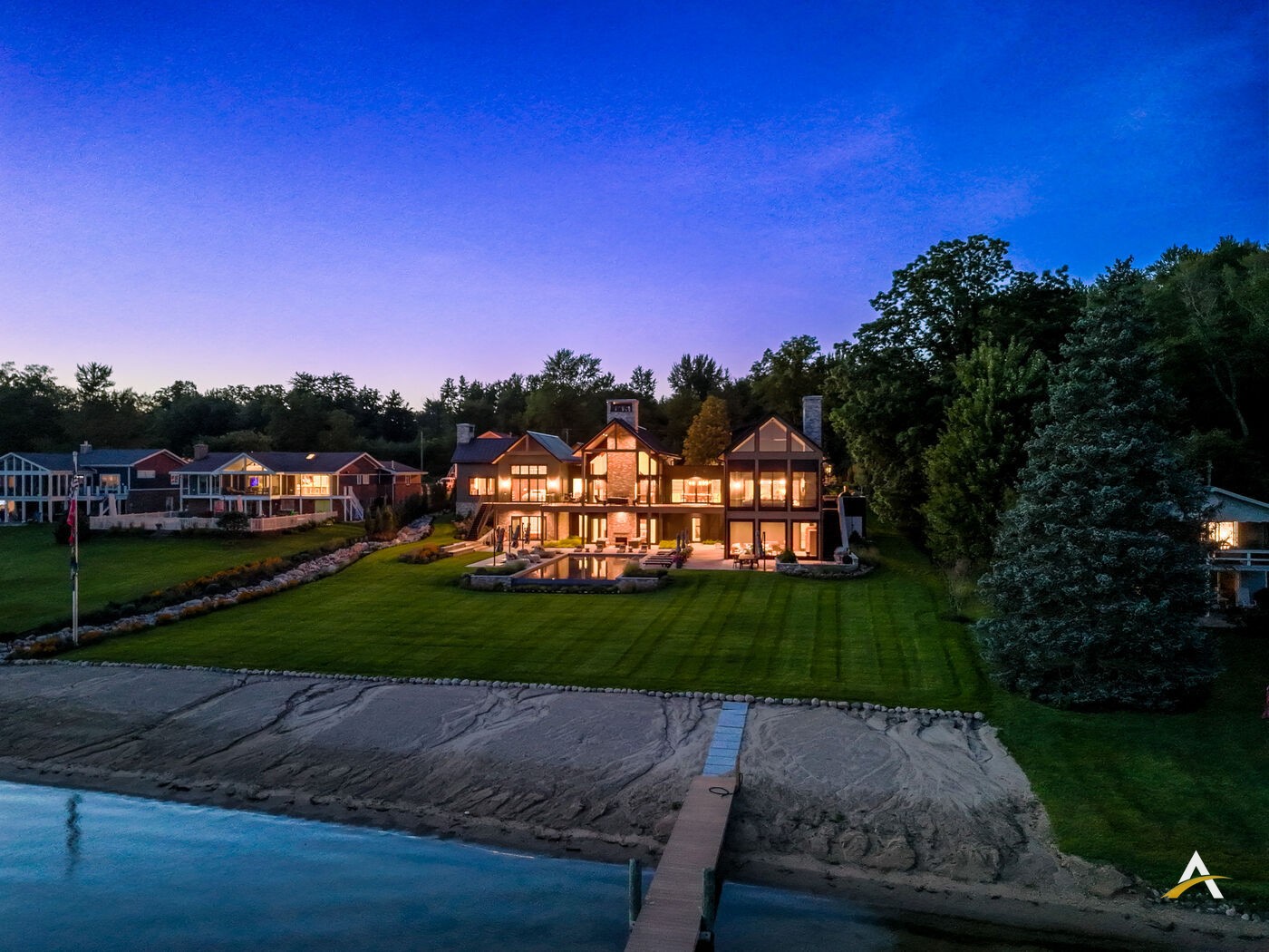 Dusk aerial view of the full property, beach, and dock