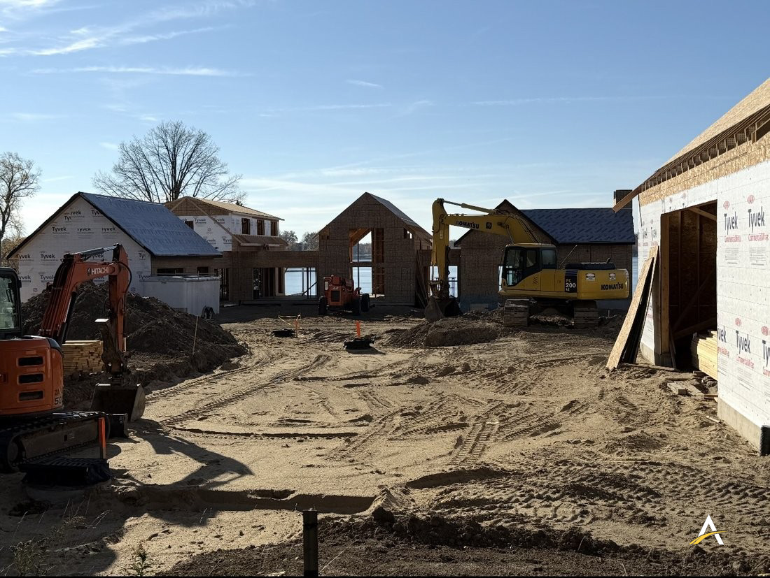 Ground-level view of multiple framed wings under construction along the lakefront