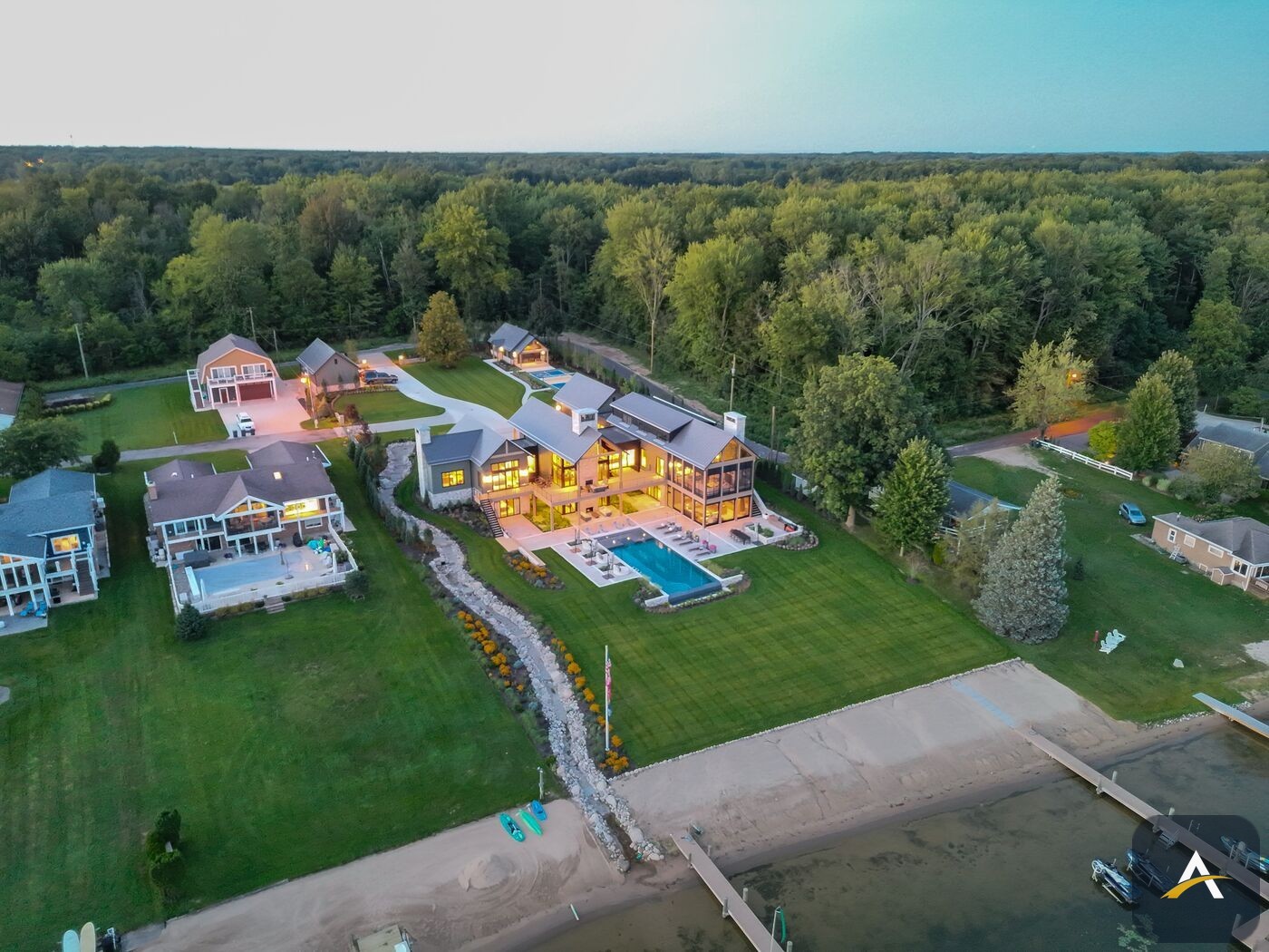 Wide twilight aerial of the property in its lakefront setting