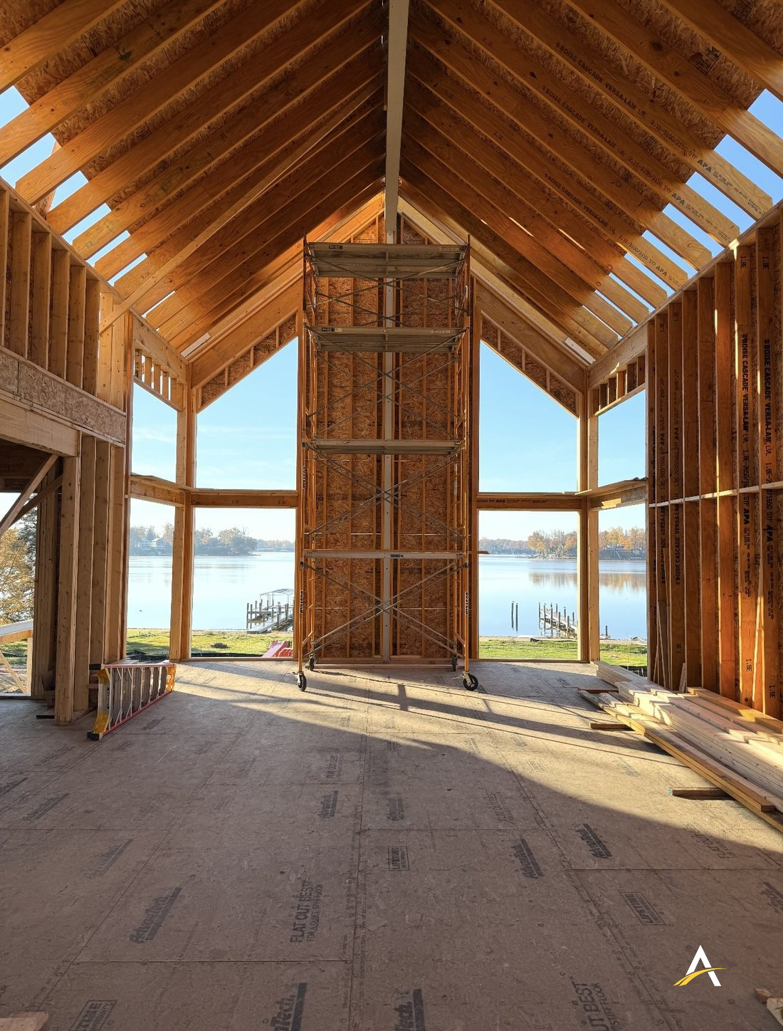 Vaulted great room framing with floor-to-ceiling windows overlooking the lake